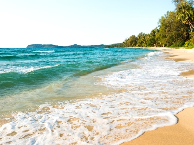 Белая пена на желтом песке на берегу океана