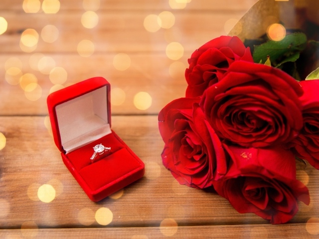 Красивый букет красных роз и кольцо с бриллиантом