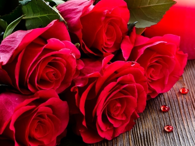 Красивый букет роз лежит на деревянной поверхности