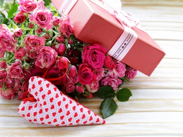 Букет розовых роз с подарком и сердечком на столе