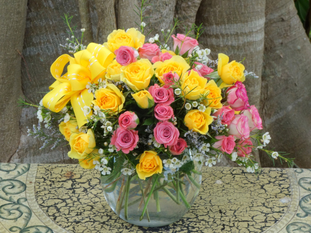 Букет желтых и розовых роз в стеклянной вазе