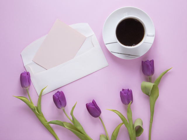 Сиреневые тюльпаны с письмом и чашкой кофе на столе 