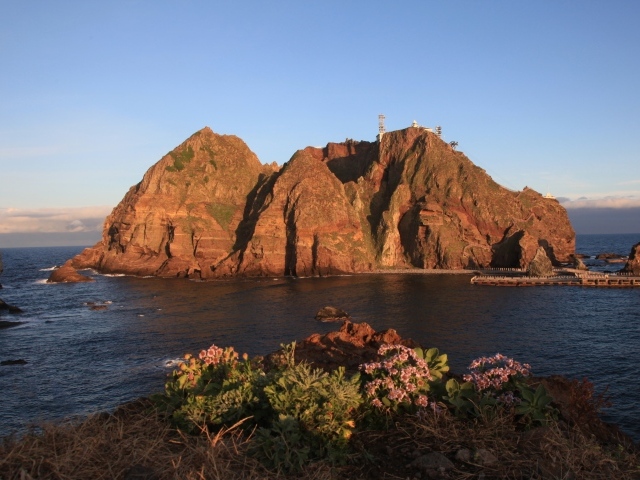 Скалистый остров в море под голубым небом