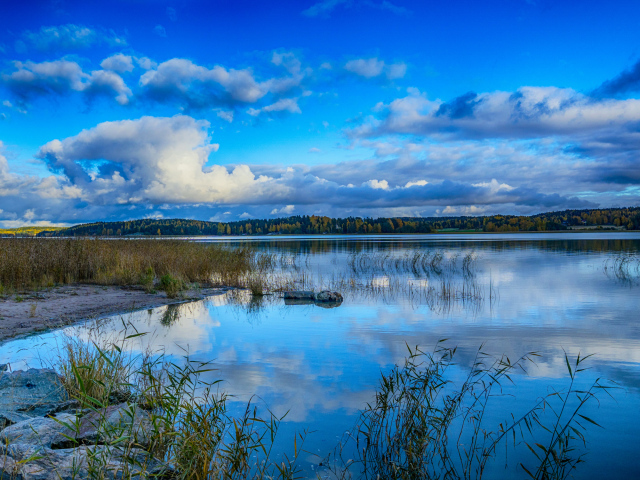 Голубое небо с облаками отражается в озере