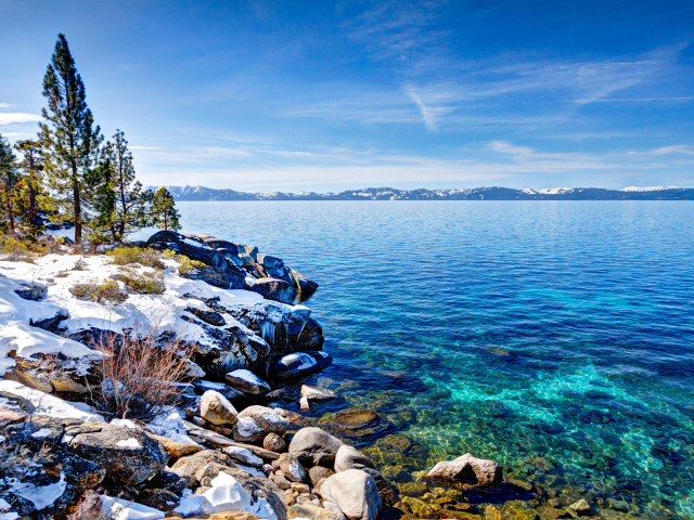 Чистая вода в озере Тахо с покрытыми снегом берегами, США