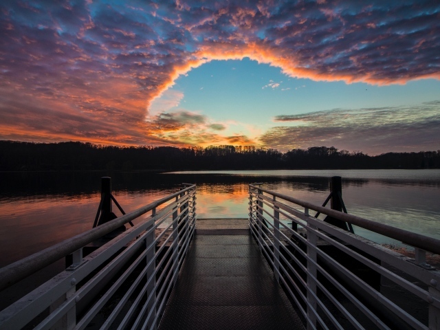 Мост на озере на фоне красивого неба на закате