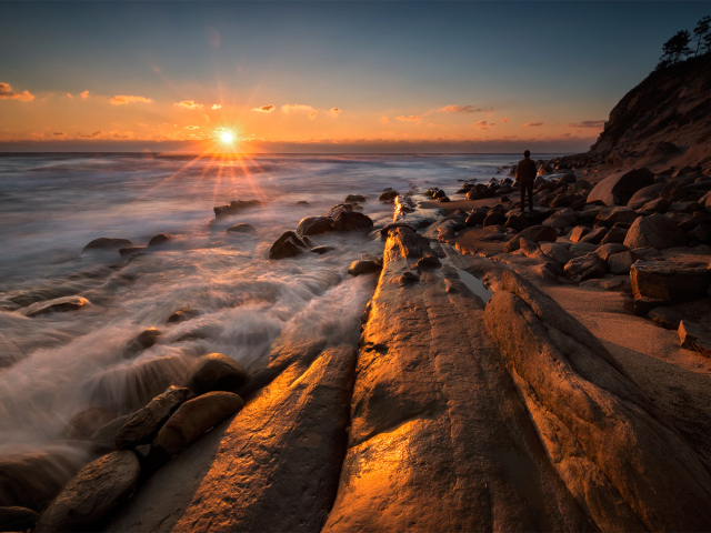 Каменный берег на морском побережье на закате солнца