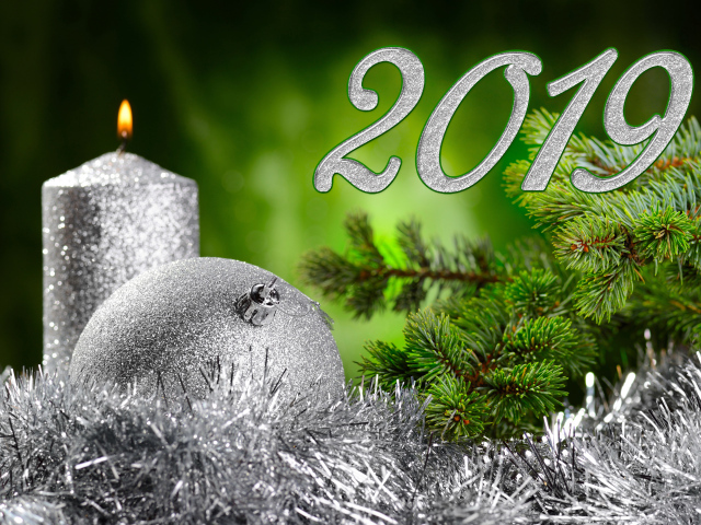 Красивый серебряный шар и свеча с еловой веткой на Новый год и Рождество 2019 