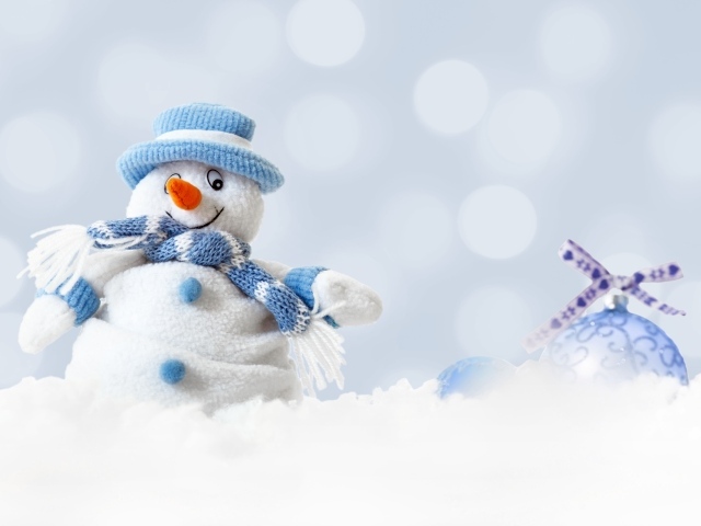 Игрушка снеговик и елочная игрушка на снегу 