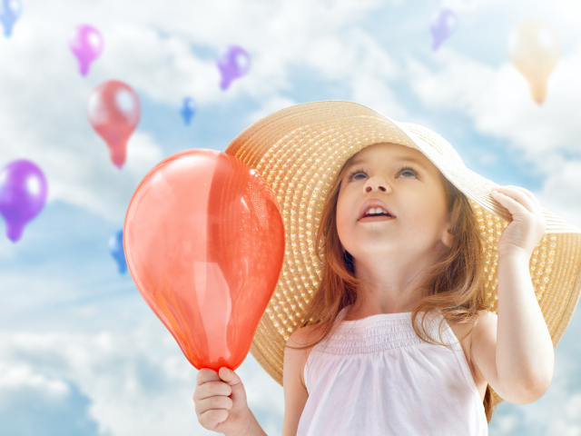 Девочка в большой шляпе с красным надувным шариком