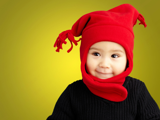 Маленький мальчик в красной шапке и в черном свитере