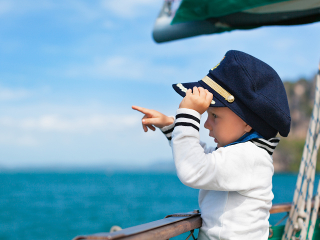 Маленький мальчик в форме капитана на корабле