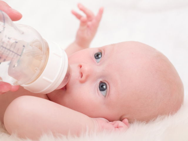 Новорожденного ребенка кормят с бутылки