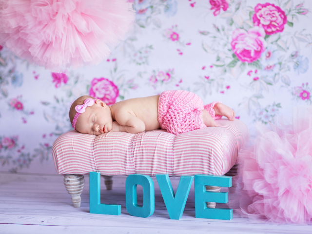 Спящий грудной ребенок в розовом костюме и надписью love