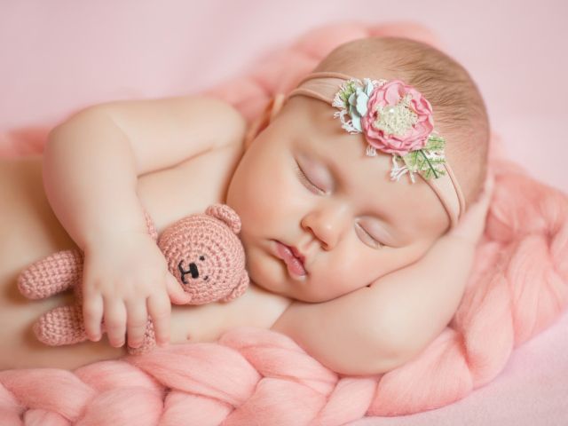 Спящая маленькая девочка с вязаным медвежонком в руке