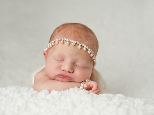 Маленький спящий грудной ребенок с красивым украшением на голове