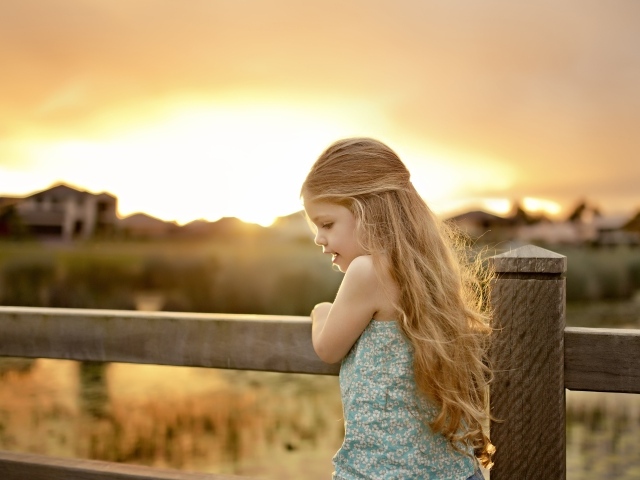 Красивая маленькая девочка на закате солнца