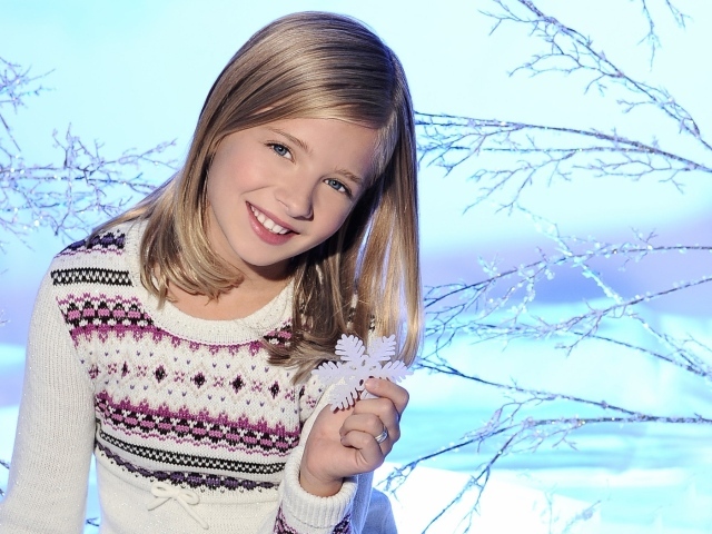 Красивая улыбающаяся девочка блондинка со снежинкой в руке