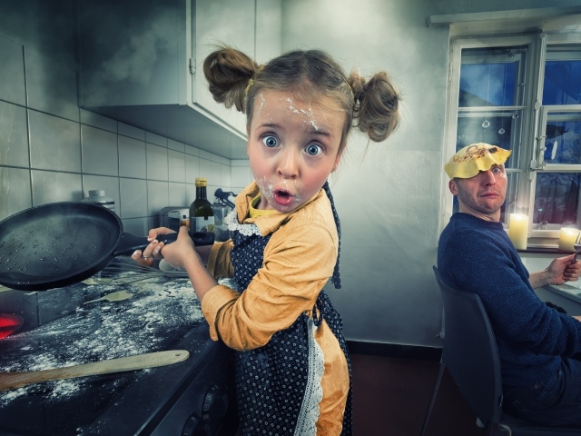 Смешная маленькая девочка готовит блины