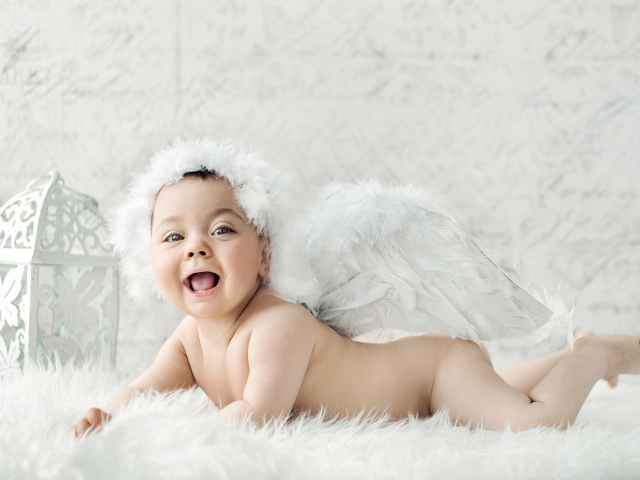 Забавный улыбающийся ребенок с крыльями ангела