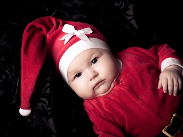 Грудной ребенок в красном новогоднем костюме