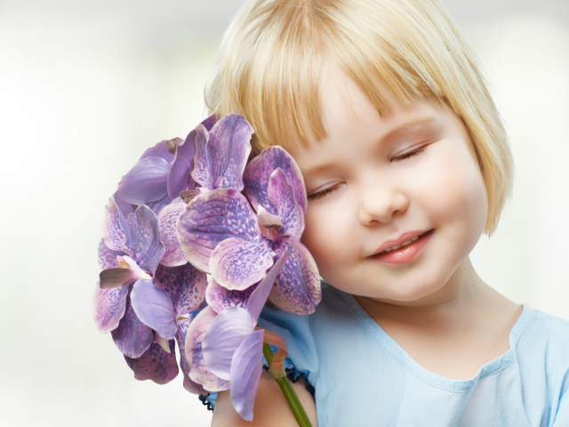 Маленькая девочка блондинка с цветами орхидеи