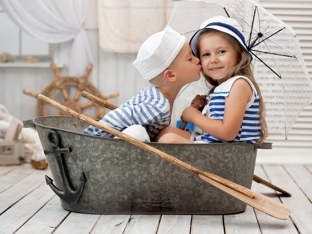 Маленькие мальчик и девочка сидят в железном корыте