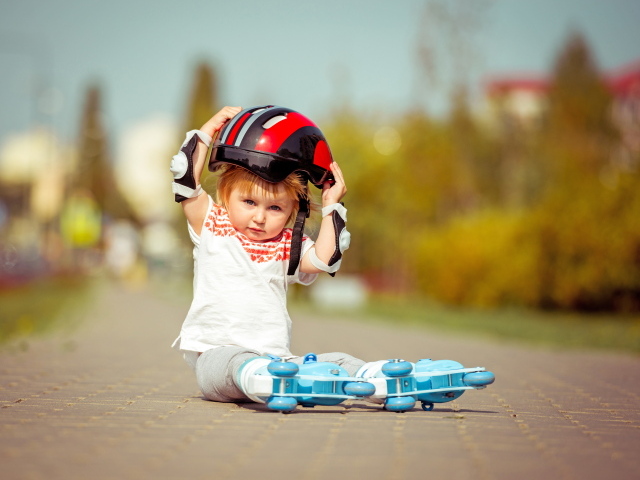Маленький мальчик в шлеме и роликовых коньках