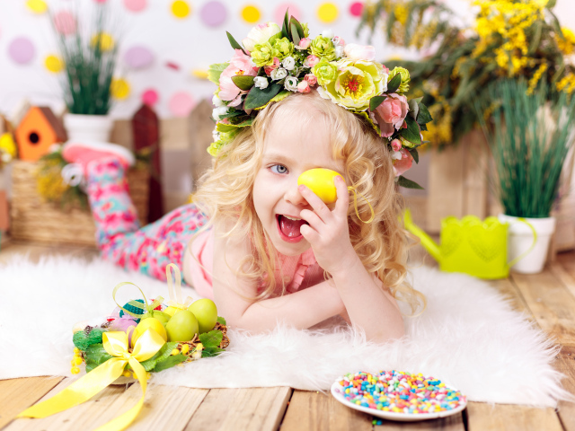 Маленькая веселая девочка с пасхальными яйцами