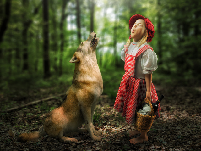 Маленькая девочка в костюме красной шапочки с волком в лесу