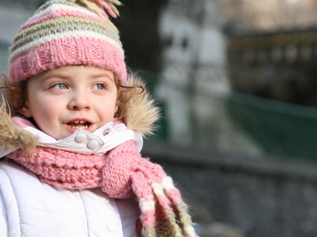 Маленькая девочка в теплой шапке с шарфом