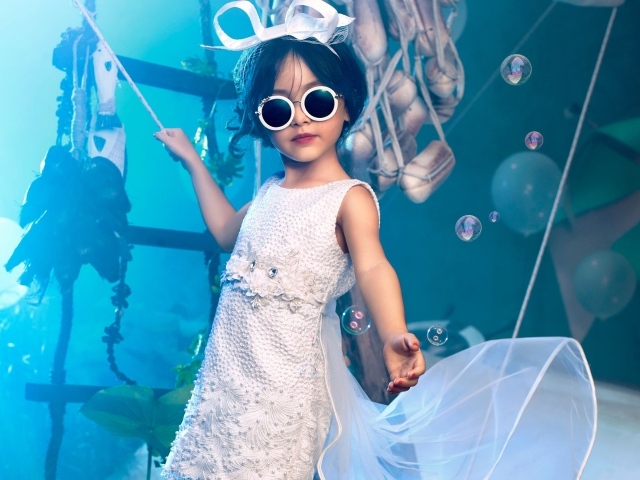 Маленькая девочка в белом платье и черных очках