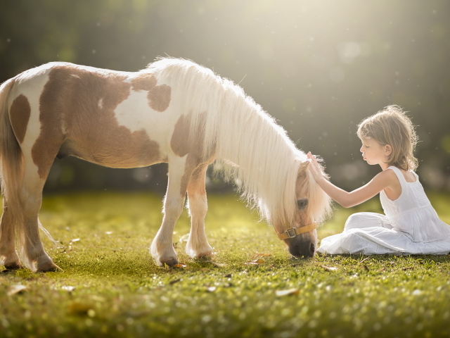 Маленькая девочка в белом платье с пони