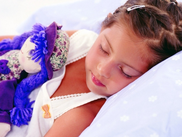 Маленькая девочка спит с игрушкой