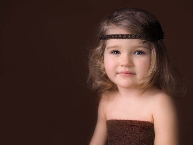 Маленькая девочка с повязкой на голове фото на коричневом фоне