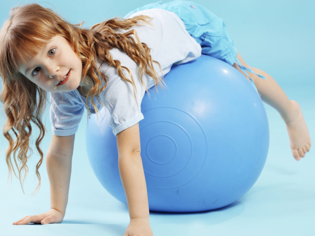 Маленькая девочка с большим голубым мячом