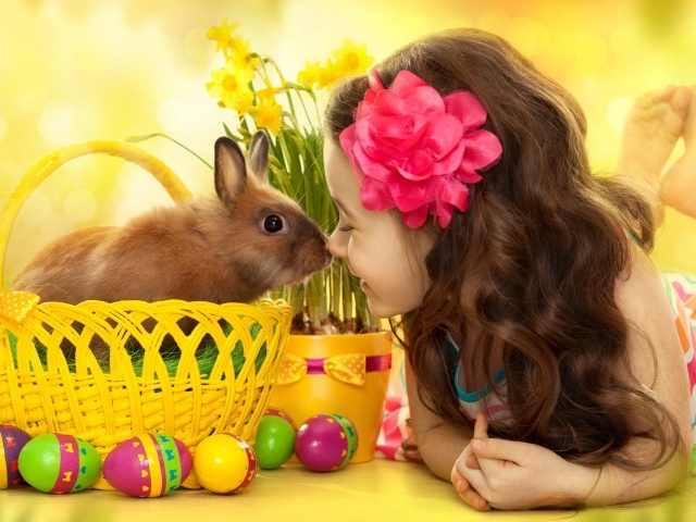 Маленькая девочка с кроликом в корзине на праздник Пасха