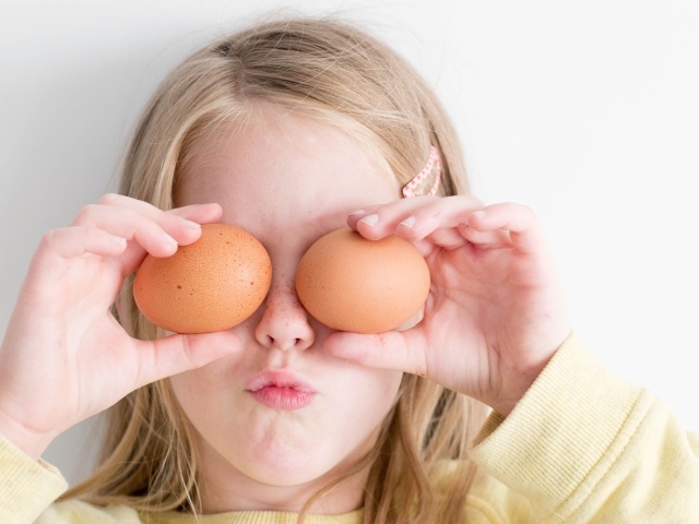 Маленькая девочка с яйцами в руках