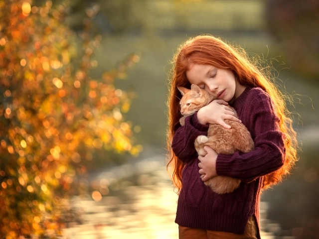 Маленькая рыжеволосая девочка с котенком на руках