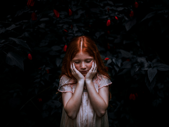 Маленькая рыжеволосая девочка с закрытыми глазами 