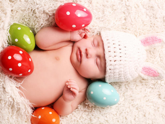 Маленький спящий ребенок с пасхальными яйцами