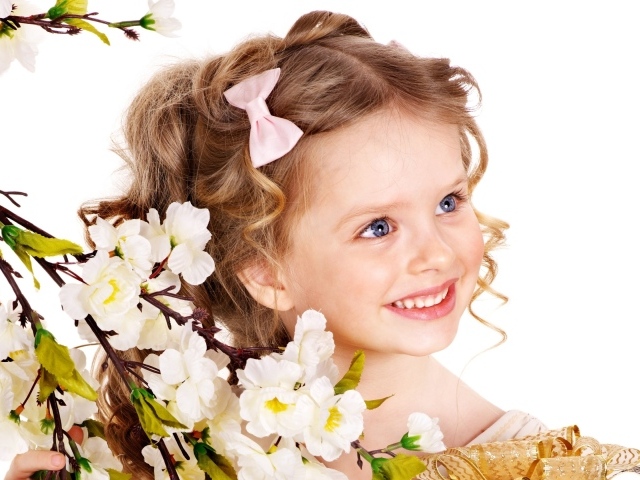 Маленькая улыбающаяся девочка с цветущей веткой