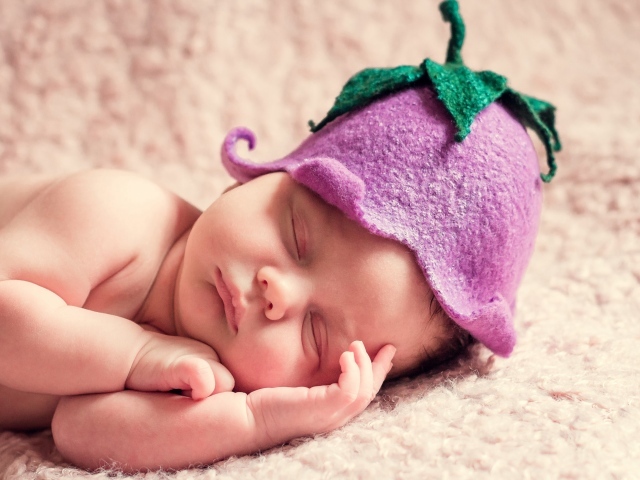 Спящий младенец в шапке в виде цветка