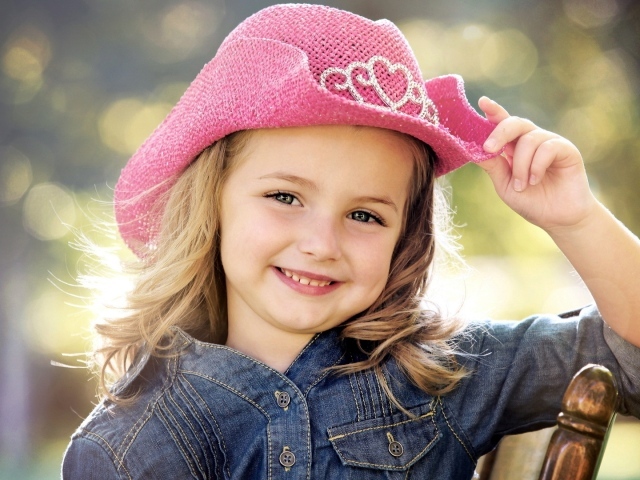 Улыбающаяся девочка в розовой шляпе
