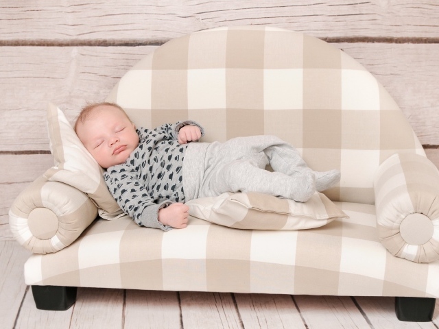 Грудной ребенок спит на диване