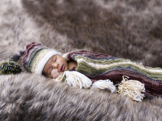 Младенец спит на меховом покрывале