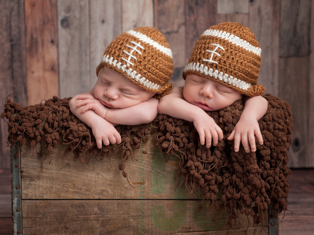Два милых спящих малыша в забавных вязаных шапках