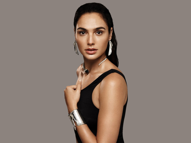 Актриса Галь Гадот в черном наряде на сером фоне