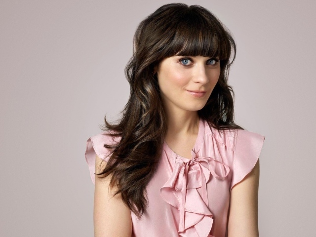 Актриса Зоуи Дешанель в розовом платье на сером фоне