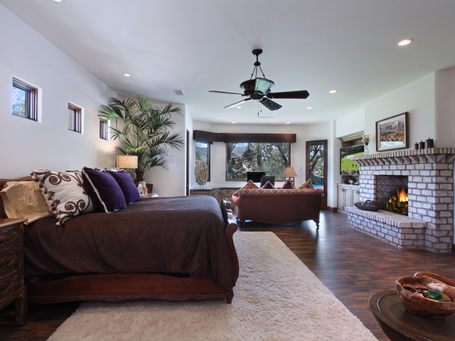 Спальная комната с большой кроватью с камином